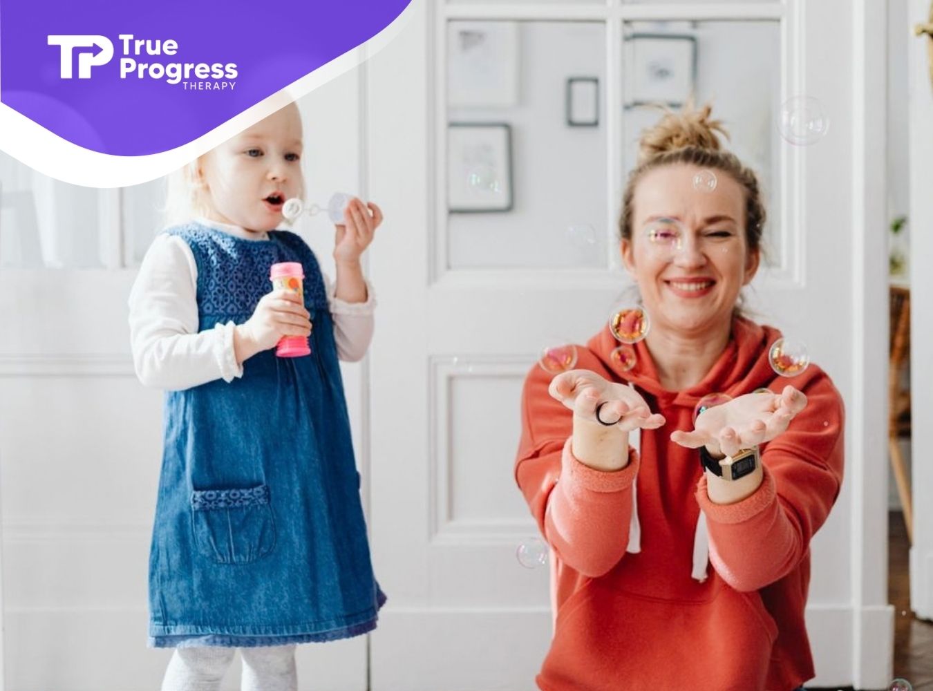 ABA therapist playing with a young child using bubbles during an in-home therapy session.